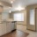 Large well lit kitchen and stainless steel apliances adjacent to the living room