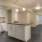Large well lit kitchen and stainless steel apliances adjacent to the living room