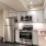 Large well lit kitchen and stainless steel apliances adjacent to the living room