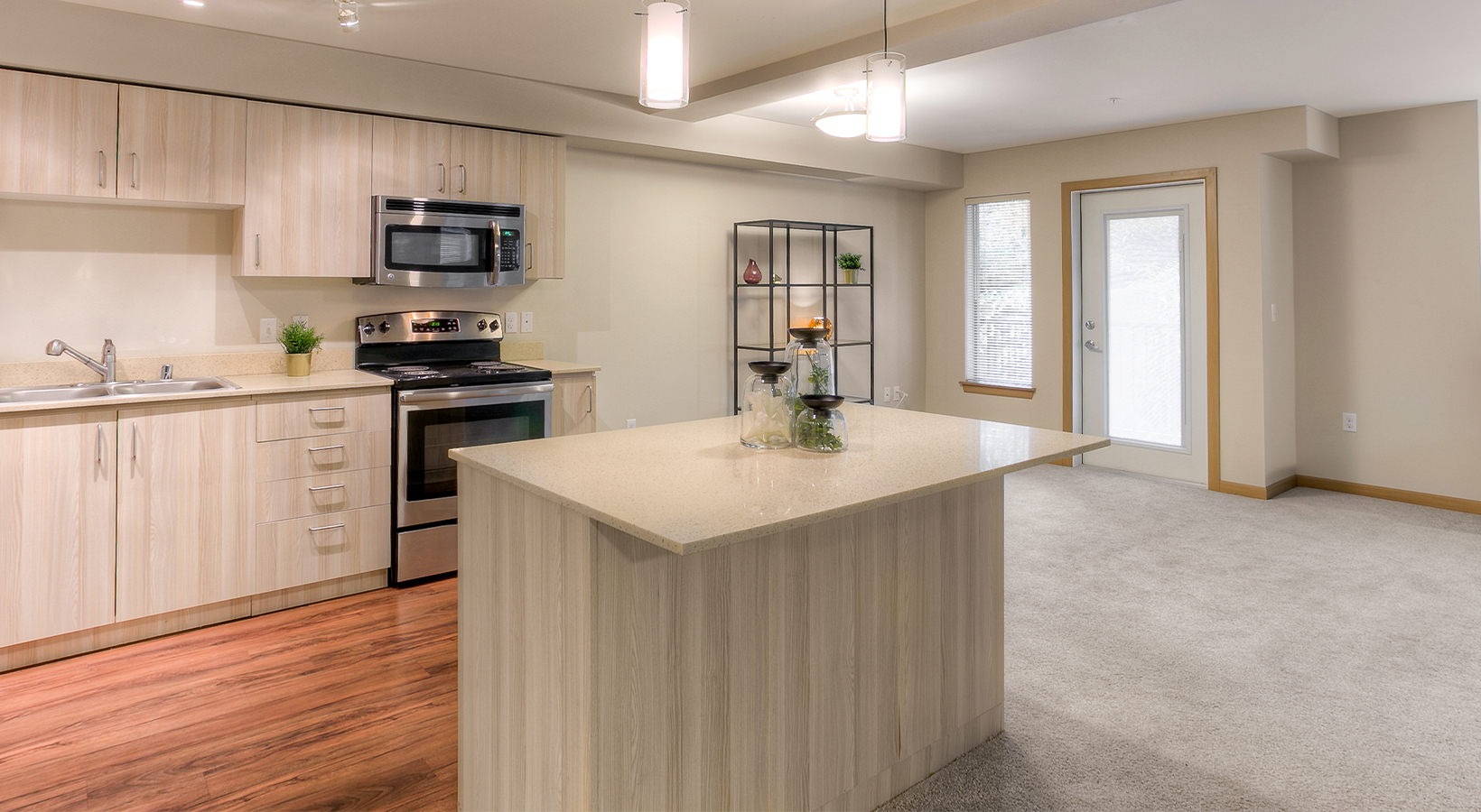 Kitchen Large well lit kitchen with island and stainless steel apliances adjacent to the living room