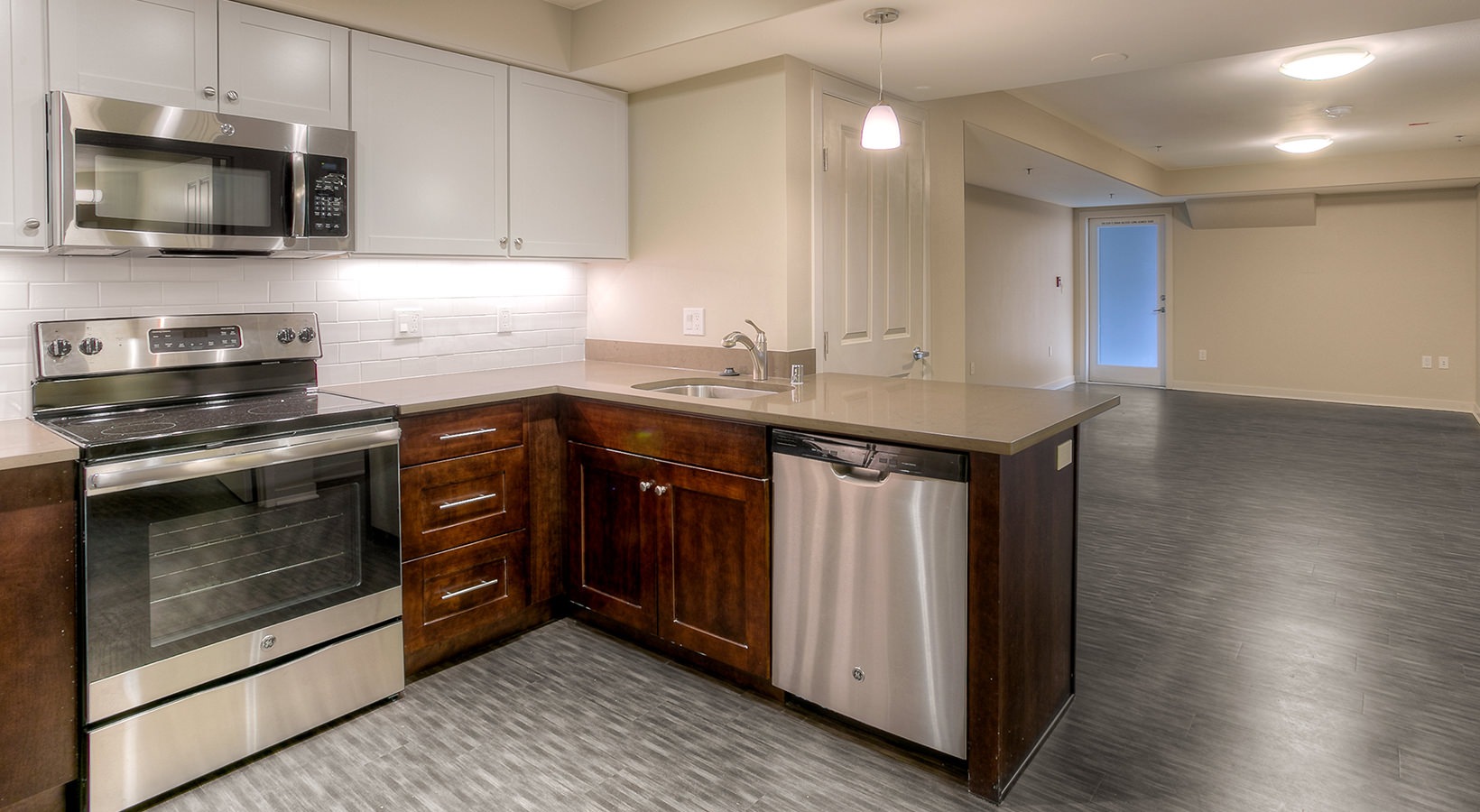 Kitchen Large well lit kitchen with dark wood cabinets and stainless steel appliances adjacent to the living room